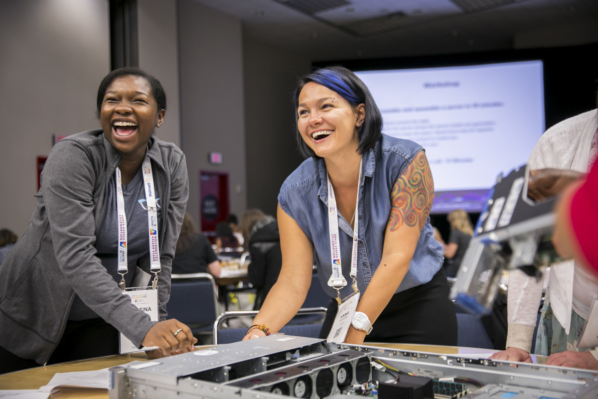 woman-laughing-while-building-a-computer-at-grace-hopper-celebration Conference